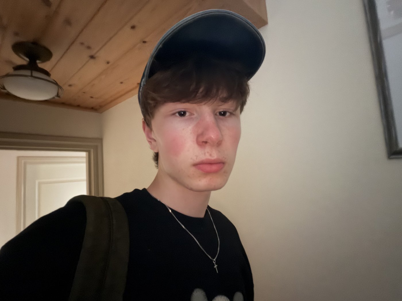 Portretfoto van Thijn van den Elzen, met een pet op en een rugzak over de schouder